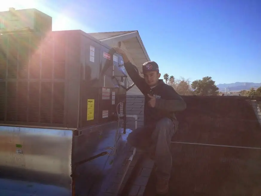 HVAC technician performing Boiler Repair on a rooftop unit in Oakdale